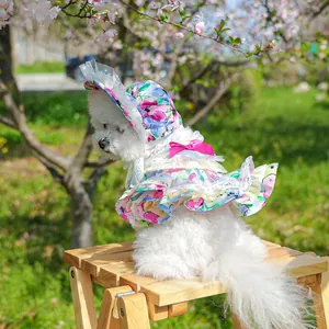 Floral dog dress with lace trim and sun hat shown on a small dog in a cherry garden