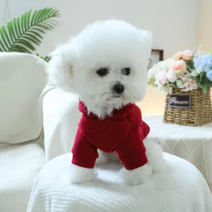 Close-up of a small dog wearing a warm dark red pet hoodie in a cozy home setting