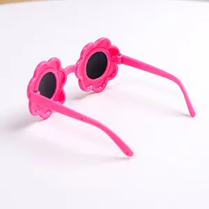 Dettaglio di occhiali da sole rosa a forma di fiore per bambini con montatura in plastica