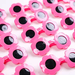 Dettaglio di occhiali da sole per animali a forma di fiore rosa con lenti rotonde nere