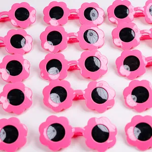 Occhiali da sole rosa a forma di fiore per animali domestici con lenti nere su sfondo bianco