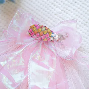 Detailed close-up of pink organza bow with shimmering sequins and pearl floral accents