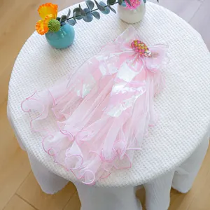 Close-up of pink layered mesh pet veil with iridescent bow and pearl details