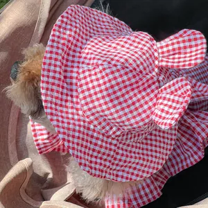 Detail of red gingham pet sun hat with cute ears and breathable cotton texture for small dogs