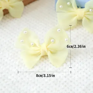 Détail d'un nœud en résille jaune avec perles pour animaux, dimensions 8cm par 6cm