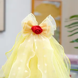 Close-up of bright yellow dog wedding veil with red rose and heart patterns