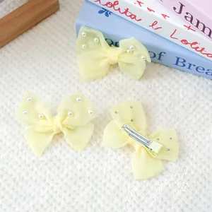 Trois barrettes à nœuds jaune pâle avec perles blanches et pince croco en métal argenté