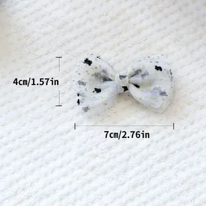 Vue détaillée du nœud en tulle blanc avec paillettes dorées et guide de taille 7x4cm