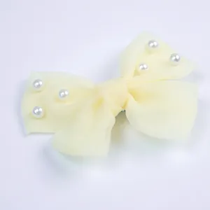 Détail du nœud en organza crème avec perles pour petits chiens et chats