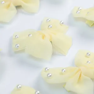 Détail du nœud papillon en organza jaune avec perles pour toilettage de chien