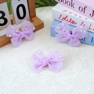 Détail macro de barrettes noeuds en mousseline violette avec perles pour petits animaux