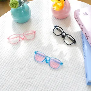 Detail van drie miniatuurbrillen voor kleine honden of poppen in roze, zwart en blauw