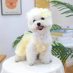 Détail de robe jaune pour animal avec bordure en perles et pince à nœud assortie