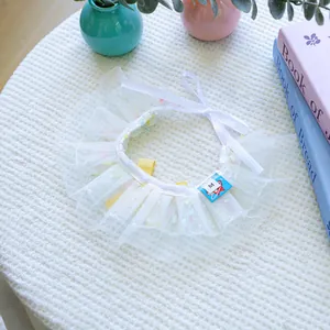 Détail d'un bavoir blanc en maille pour animaux avec dentelle florale et étiquette M