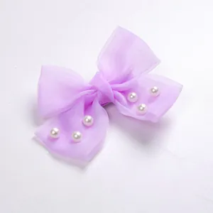 Gros plan d'un nœud papillon en organza lavande avec perles blanches pour petits animaux