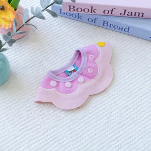Detail of pink and purple petal-shaped pet bib with a yellow heart on white knit