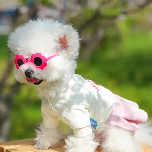 Dettaglio del set estivo per cani con top a coste avorio e occhiali a fiori rosa