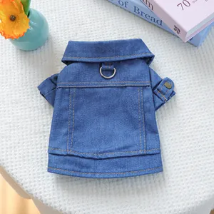 Detail of blue denim dog jacket featuring metal D-ring and yellow contrast stitching