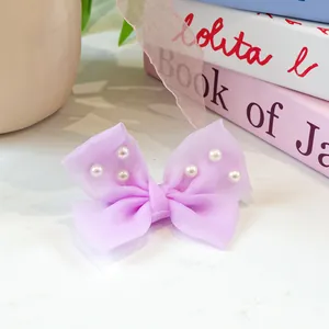 Détail de la pince à cheveux noeud en tulle violet avec perles pour petits chiens et chats