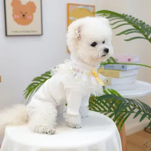 Détail d'un pull en tricot blanc pour animaux avec col en dentelle et nœud jaune