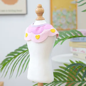 Detailed view of a pink felt pet bib with yellow heart patterns on a white mannequin