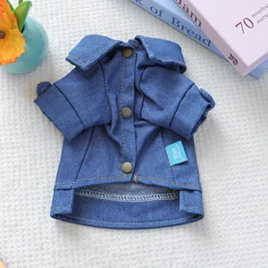 Detail of blue denim dog shirt with yellow stitching, round buttons and PETCIRCLE label