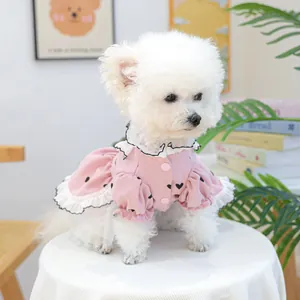 Dettaglio di un vestito rosa per cani con stampa a cuori e colletto a balze su un cane