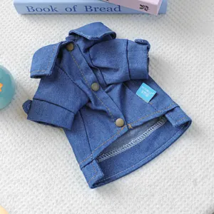 Detailed view of blue pet denim jacket with copper buttons on a textured white rug