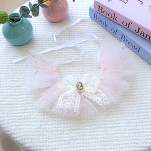 Détail de bavoir rose pour chien en tulle avec nœud en dentelle et pendentif camée