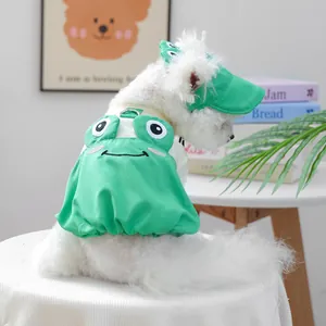Detail of dog wearing a green frog-style sun hat and matching pet harness outfit