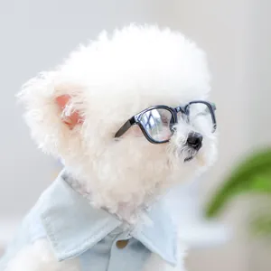 Detailopname van witte puppy met zwarte retro bril en een blauw denim overhemd