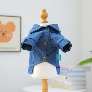 Detail of the dark blue denim pet jacket with metal buttons and stitched branding