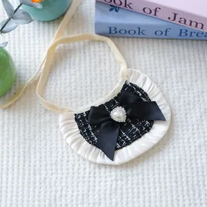 Detail of tweed pet bandana with heart pearl accent and white lace trim on cream background