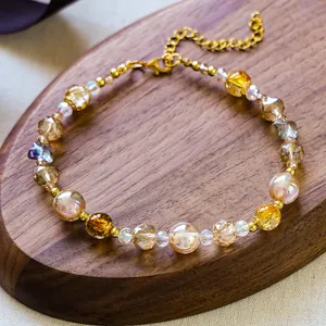 Détail du collier pour animaux avec perles ambre et cristal sur plateau en bois
