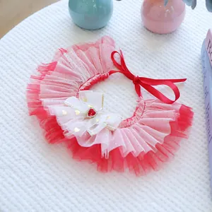 Détail d'un bavoir rouge pour animal avec nœud en maille et gemme en forme de cœur