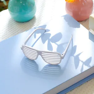 Detailopname van witte shutterbril voor huisdieren op een blauw boek met schaduwen