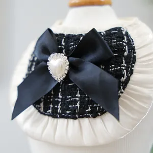 Macro shot of tweed pet bandana with satin bow, heart pearl, and rhinestone detail