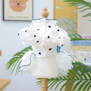 Dettaglio di vestito bianco per cani con cuori neri, volant e orlo in tulle leggero