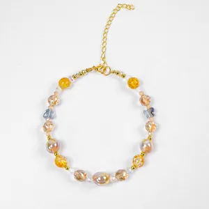 Détail du collier pour animaux avec perles d'ambre, papillon en verre et fermoir doré