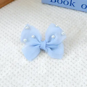 Gros plan sur un nœud papillon en tulle bleu clair avec perles blanches pour petit chien