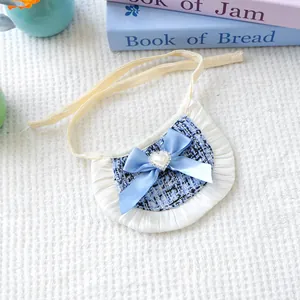 Close-up of blue tweed pet bandana with white pleats, satin bow and heart pearl detail