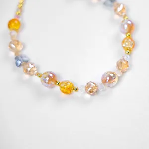 Détail macro de perles en cristal jaune chaud et pierres ambrées pour colliers d'animaux