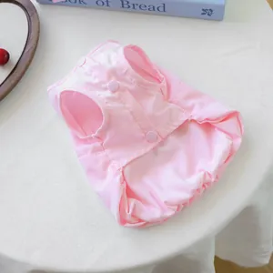 Roze mouwloos huisdier vest met decoratieve knopen op een getextureerde stoffen achtergrond