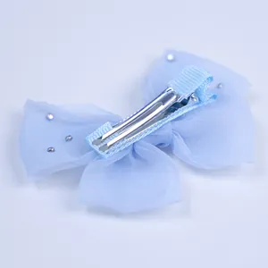 Détail d'un nœud papillon bleu clair en tulle avec pince crocodile en métal argenté
