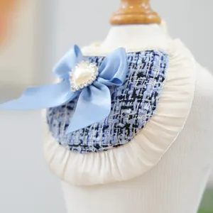 Detailed macro view of a light blue tweed dog bandana with pearl heart and lace trim