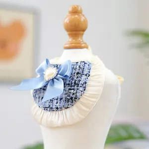 Detail of blue tweed pet bandana with satin bow and heart pearl on a white mannequin