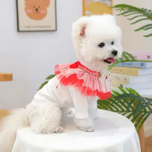 Détail d'un bavoir tricoté pour animaux avec volants en tulle rouge et petit nœud blanc
