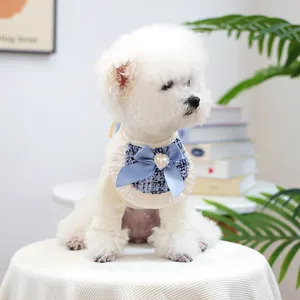 Detail of dog neckwear with blue tweed bib, satin bow and pearl heart on white knit