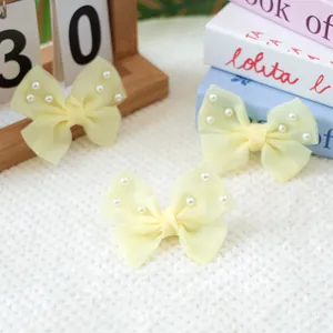 Gros plan de nœuds papillon en mousseline crème avec perles pour petits animaux ou filles