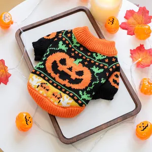 Macro view of Halloween pet sweater with pumpkin knit pattern on warm wood background